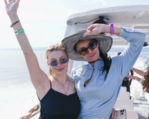 Dos chicas disfrutando de un paseo en catamarán en Samaná, rodeadas de mar turquesa.