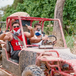 Dos personas felices manejando un buggy, disfrutando de la aventura