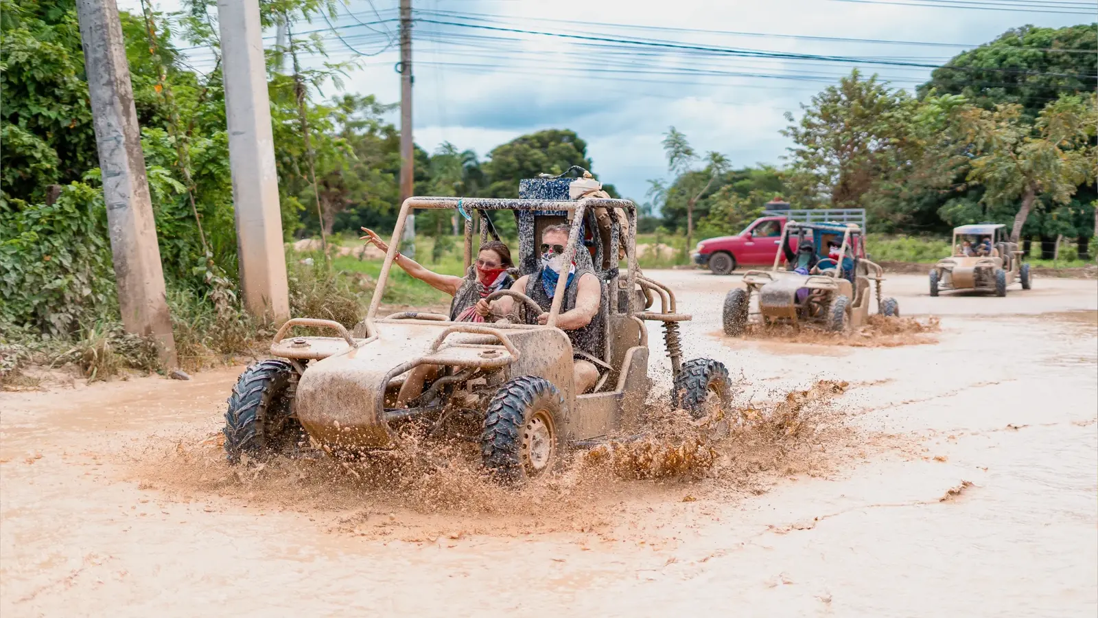 Grupo de personas cruzando un terreno lodoso durante su aventura en buggies