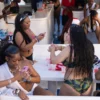 Personas bailando y disfrutando en una fiesta en barco en aguas cristalinas.
