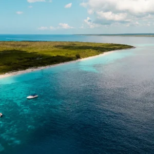Vista aérea de la playa de Isla Catalina con un catamarán navegando en sus aguas turquesas.